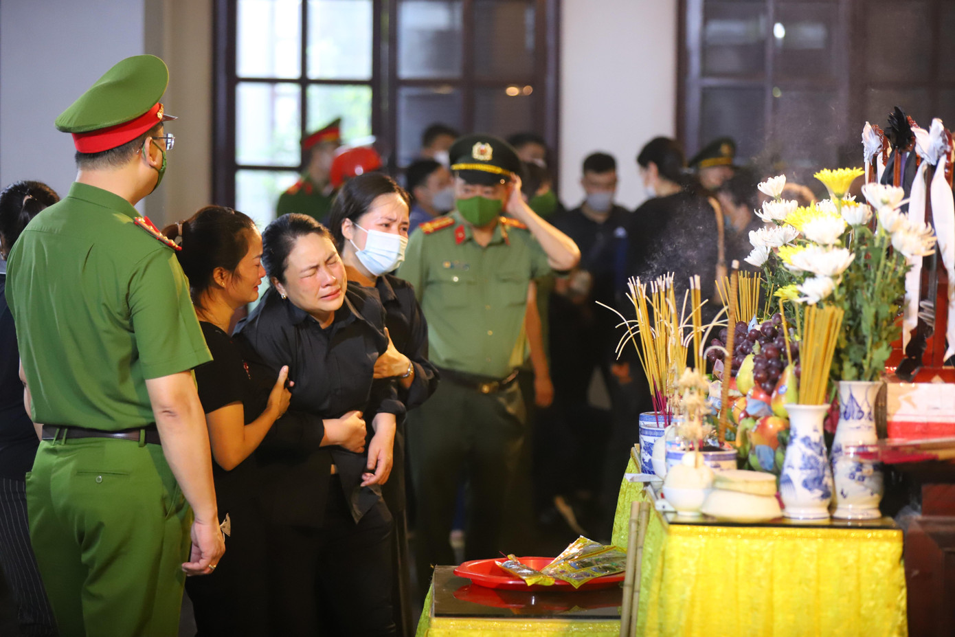 Bà Nguyễn Thị Cúc, mẹ Thượng úy Đỗ Đức Việt phải nhờ đến người thân mới có thể đứng vững tại Lễ khâm liệm và nhập quan con trai và đồng đội của con trong sáng 5/8, tại nhà tang lễ Bệnh viện 198 (Hà Nội). (Ảnh: Duy Phạm)