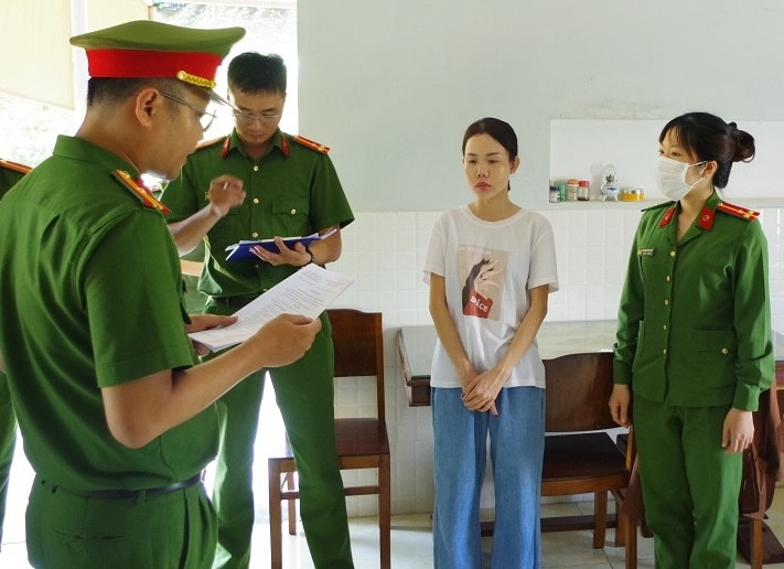 Công an đọc lệnh khởi tố đối tượng Đặng Trúc Quỳnh (áo trắng). Ảnh: Tiến Quân.