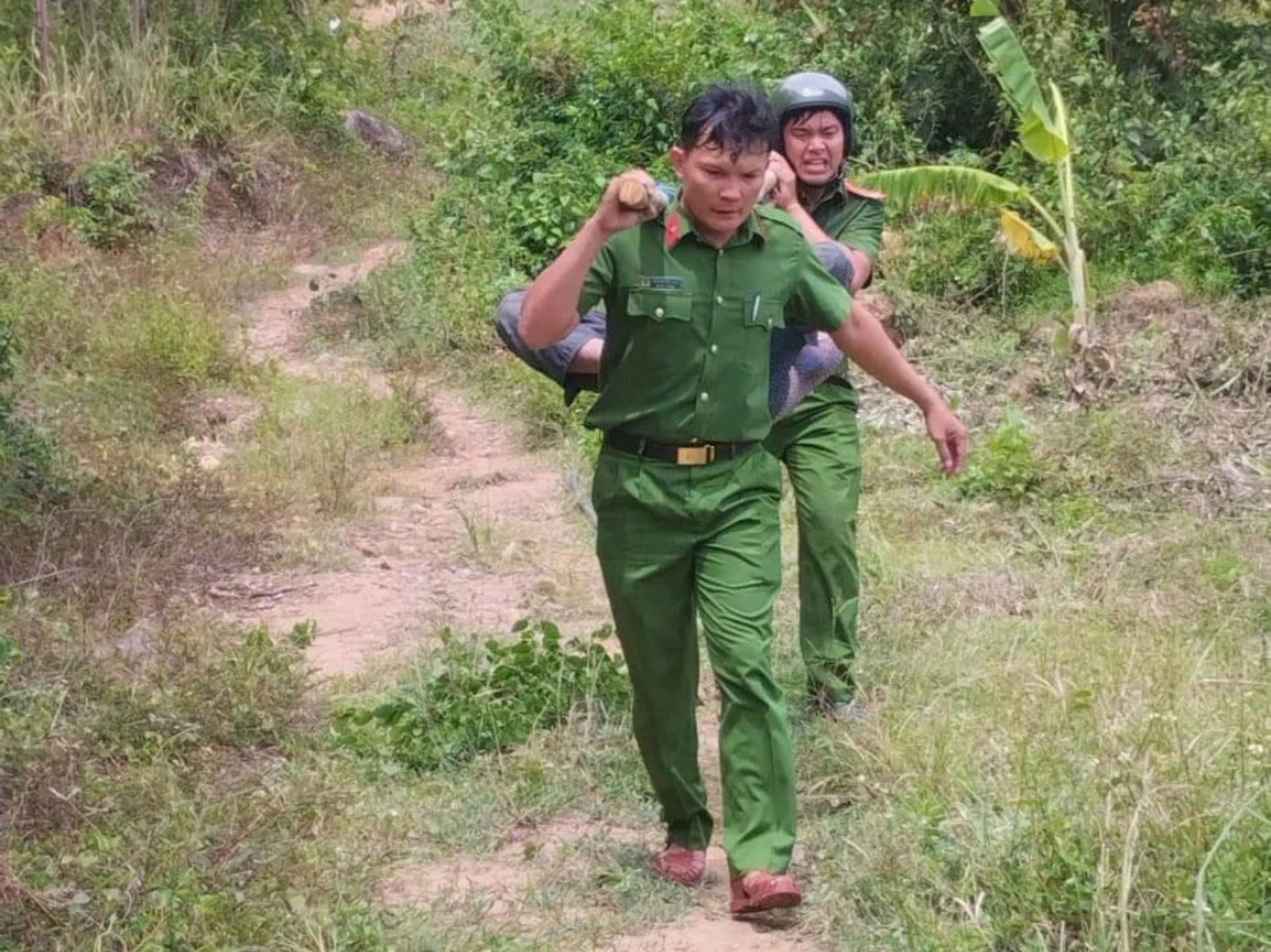 Cán bộ Công an xã Hòa Quang Bắc dùng cáng võng đưa người dân ra khỏi rừng. Ảnh: M.N.