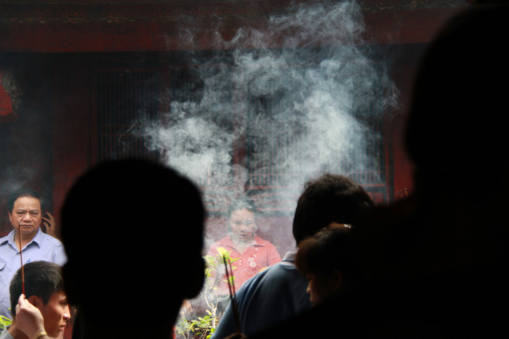 Ban tổ chức liên tục nhắc nhở việc mỗi người chỉ châm một nén hương, nhưng, hầu hết mọi người đều không nghe. Việc đốt quá nhiều hương khiến khói bốc nghi ngút, ngột ngạt. Ảnh: Trường Phong