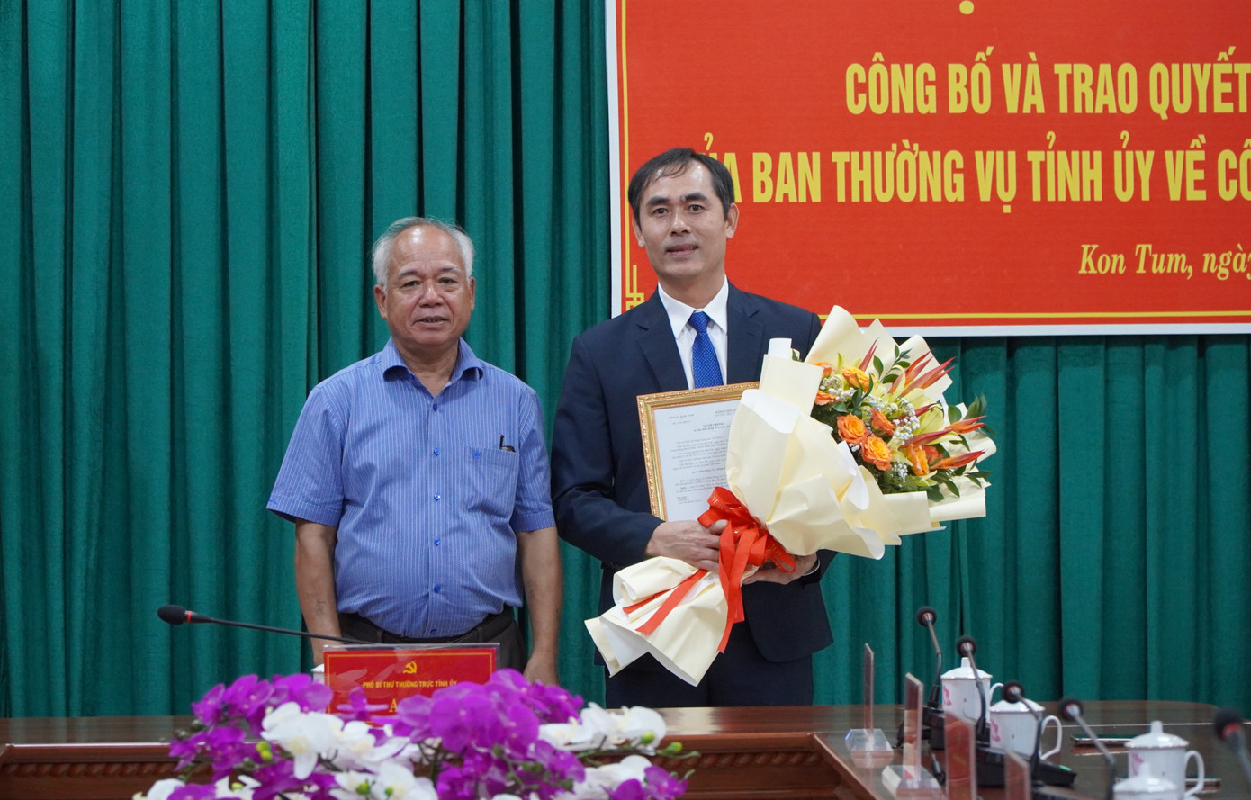 Phó Bí thư Thường trực Tỉnh ủy Kon Tum (trái) trao quyết định và tặng hoa chúc mừng tân Phó trưởng Ban Tổ chức Tỉnh ủy