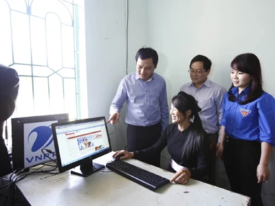 NSNA Mai Nam và ông Mai Văn Hậu, những người có mặt làm số báo đầu tiên tại Bản Dõn năm 1953, tặng quà cho các học sinh trường 19/8 xã Minh Thanh. Ảnh: Như ý