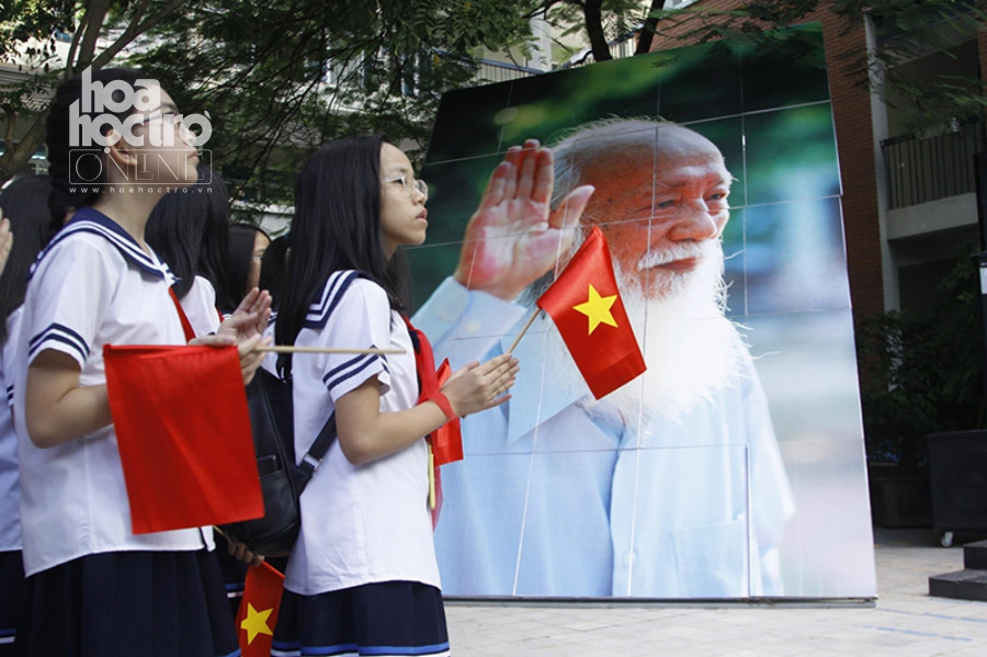 Học sinh trường Lương Thế Vinh sáng nay, bên cạnh là bức hình về thầy giáo Văn Như Cương.