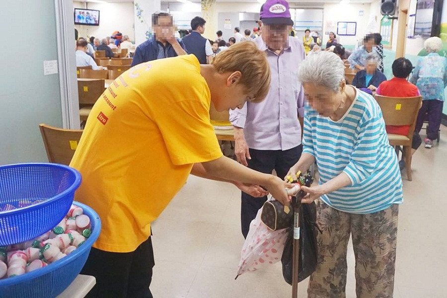 Họ thường xuyên có mặt tại trung tâm chăm sóc người già. Cậu bé Haechan lễ phép đưa đồ bằng hai tay cho cụ già.