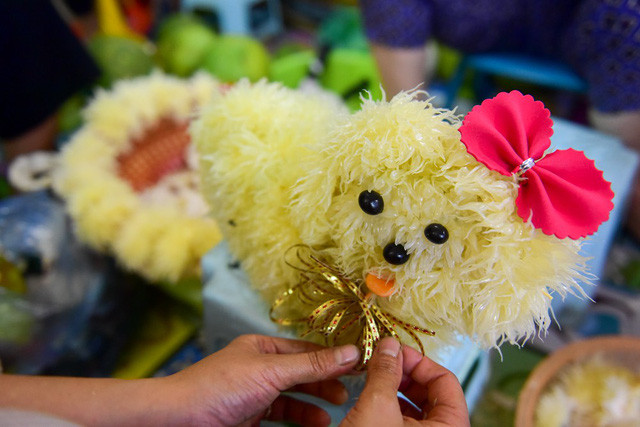 Năm nay là năm Mậu Tuất, linh vật con chó được làm và bán nhiều nhất. Sau khi hoàn thiện, chú chó làm từ bưởi được gắn mắt mũi và nơ để thêm phần sinh động.