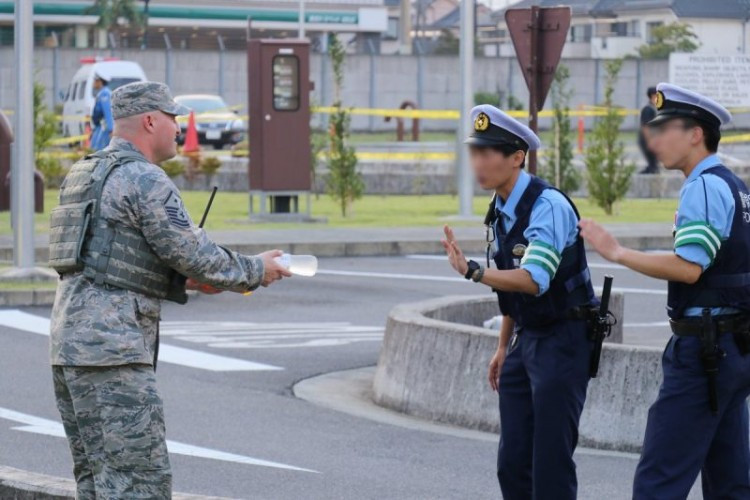 Hai cảnh sát Nhật từ chối chai nước của anh lính Mỹ.