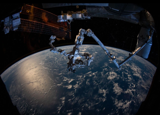 Cánh tay của robot Canadarm2 nhô ra từ một bên ISS.