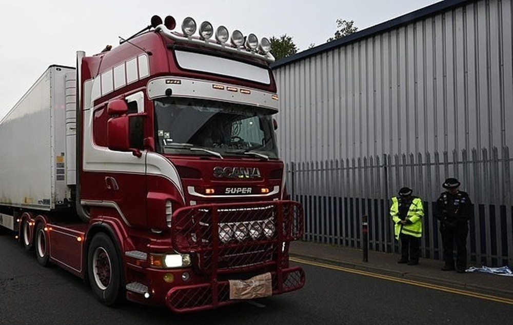 Cảnh sát cúi đầu khi chiếc xe chở 39 nạn nhân rời khỏi khu công nghiệp Waterglade ngày 24/10.