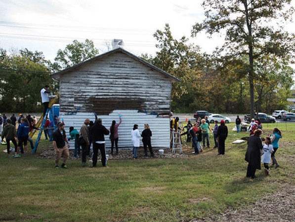 Người dân địa phương đến khắc phục hậu quả của việc vẽ bậy ở ngôi trường cổ.