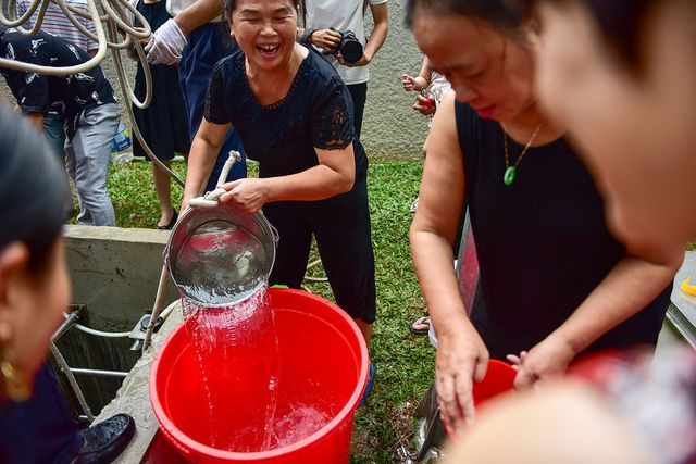 Người phụ nữ sung sướng vì lấy được những gầu nước đầu tiên.