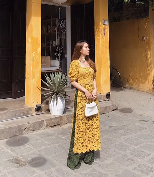 Yến Trang cho thấy độ sành mốt khi kết hợp những xu hướng hot nhất trong một chiếc áo dài: tay bồng, cổ vuông cổ điển và chất liệu ren không gò bó.