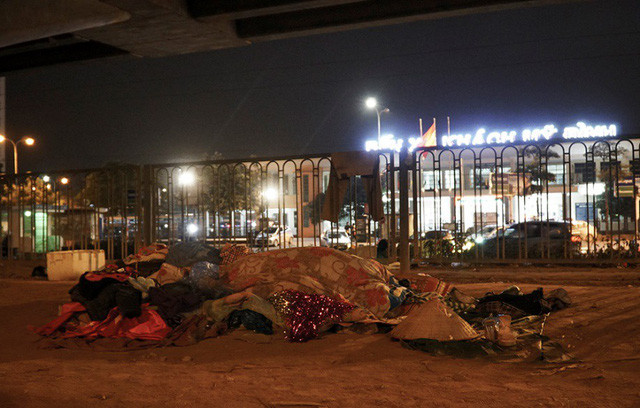 Những người vô gia cư quấn chăn ngủ ngoài trời ở khu vực gần bến xe Mỹ Đình.