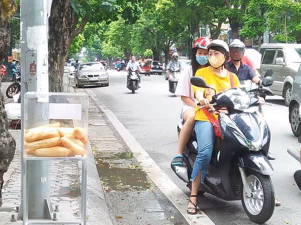 Nhiều người đi đường bất ngờ khi thấy thùng bánh mỳ miễn phí trên vỉa hè.