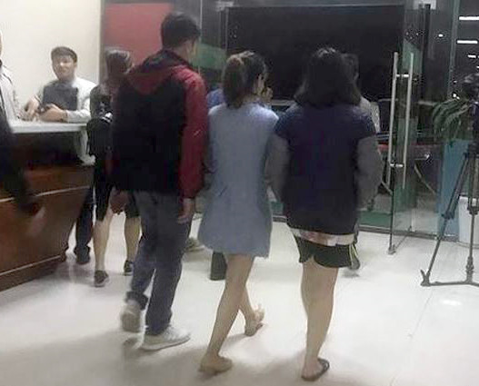 Nữ sinh 21 tuổi (ngoài cùng bên phải) được cảnh sát đưa đi sau vụ việc. (Ảnh: N.Đ)