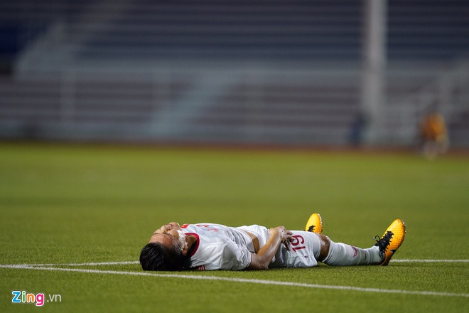 Quang Hải nằm sân đau đớn sau khi dính chấn thương ở trận gặp U22 Singapore. Ảnh: Việt Linh.