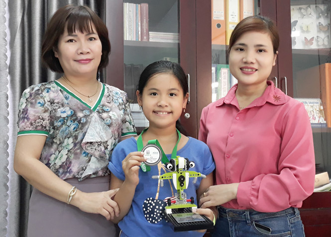 Trần Minh Trang cùng với cô hiệu trưởng (trái) và cô giáo dạy lego lập trình (phải). ẢNH: AN DY.