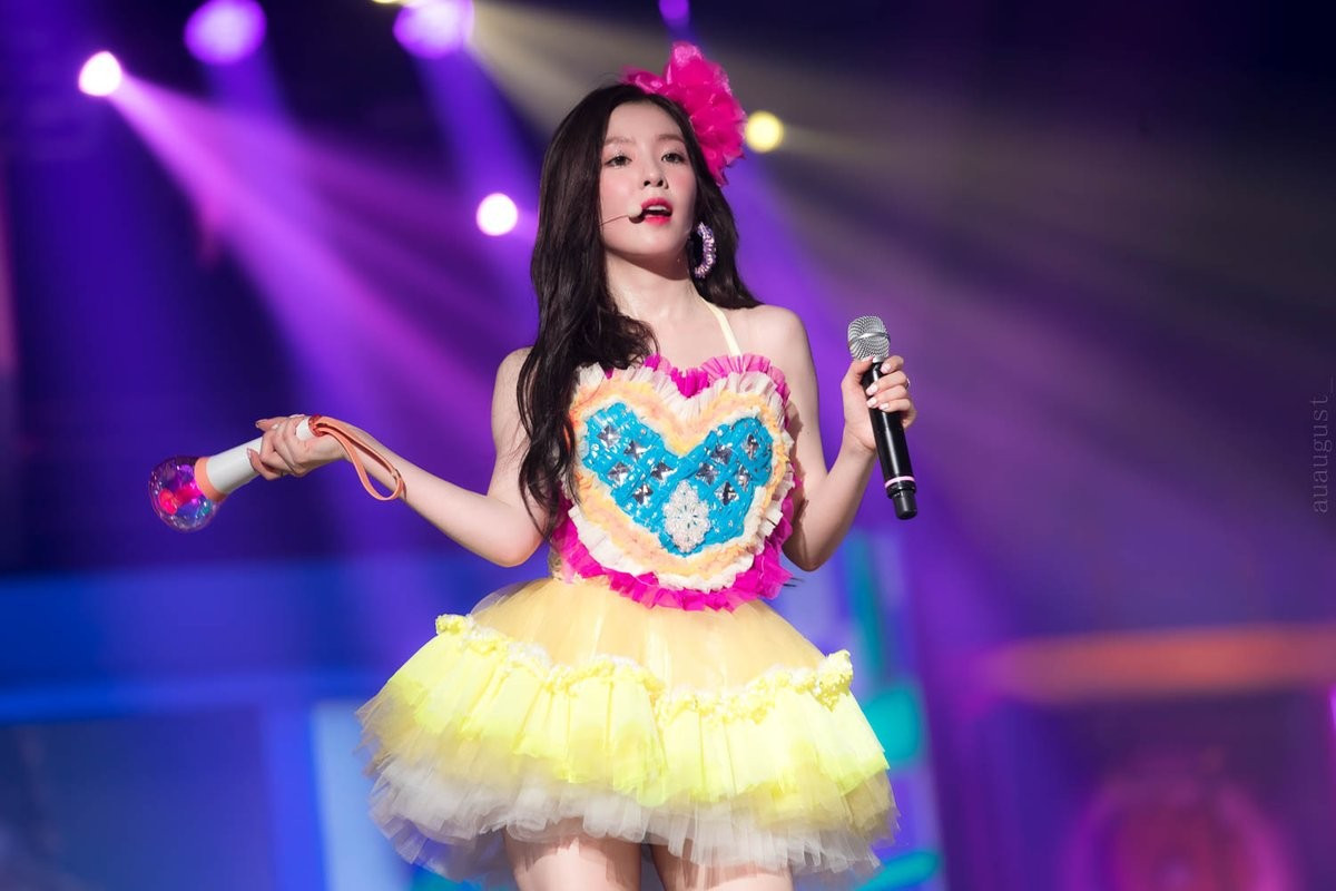 Ngoài sân bay đã vậy, trên sân khấu thì Irene cũng không được mặc đồ đẹp. Bỏ qua chuyện váy quá ngắn bất tiện đủ đường, thì thiết kế này khiến Irene nhìn như trẻ em mẫu giáo vậy. Từ màu sắc đến các đường diềm xếp hình trái tim đều quá cũ kỹ và lạc mốt.