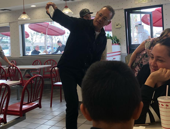 Tom Hanks cầm điện thoại chụp ảnh cùng các thực khách.