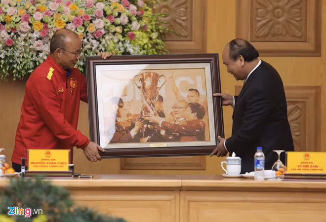 Thủ tướng Nguyễn Xuân Phúc trao tặng món quà lưu niệm cho HLV Park Hang-seo sau khi nhận được quả bóng kỷ niệm từ các thành viên của đội tuyển Việt Nam.