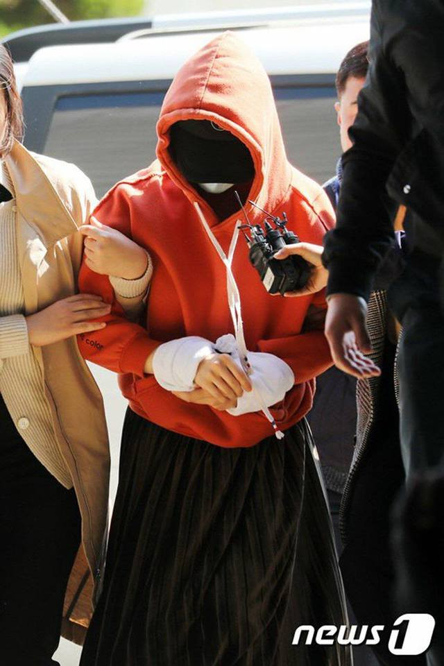 Hwang Hana che kín mặt, cúi đầu khi bị dẫn đến đồn cảnh sát.