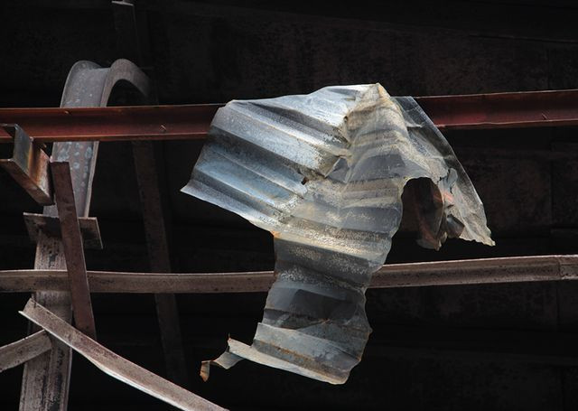 Nhiều tấm tôn treo lẳng lơ trên thành khung sắt.