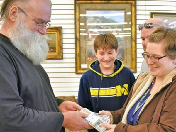 Ông Kirby trao trả lại toàn bộ tiền cho gia đình cô Fauth-Newberry (bên phải).