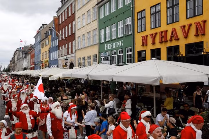 Mọi người trong trang phục ông già Noel đi bộ dọc con phố Nyhavn ở Copenhagen