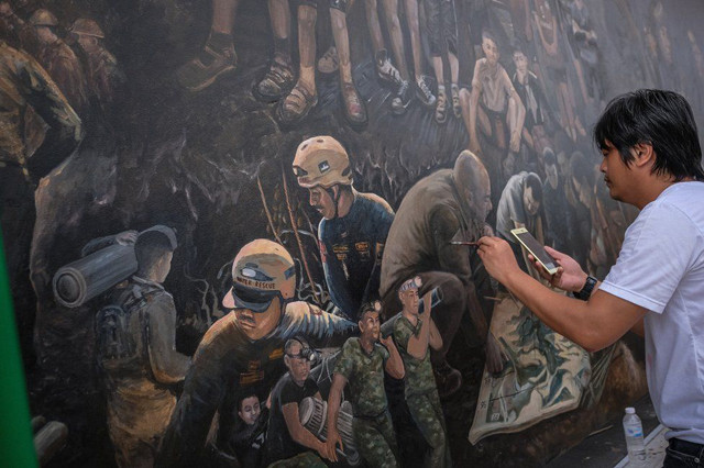 Người nghệ sĩ đang tỉ mẩn từng nét vẽ.