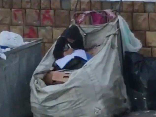 Halime Cuma ngồi học trên đống phế liệu.