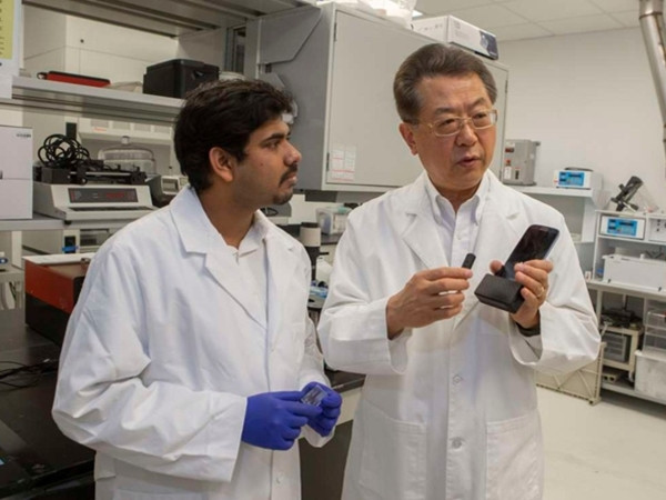 Giáo sư Chong Ahn (phải) và một đồng sự đang thảo luận về nền tảng khoa học của thiết bị mới.