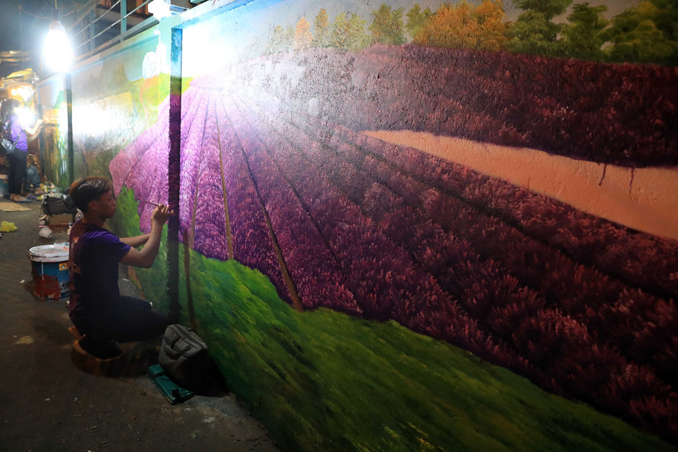 Việc “mặc áo mới” cho bức tường lối vào chợ bằng những cánh đồng hoa khiến chợ hoa Hồ Thị Kỷ thêm sắc màu rực rỡ hơn ẢNH: LAM NGỌC