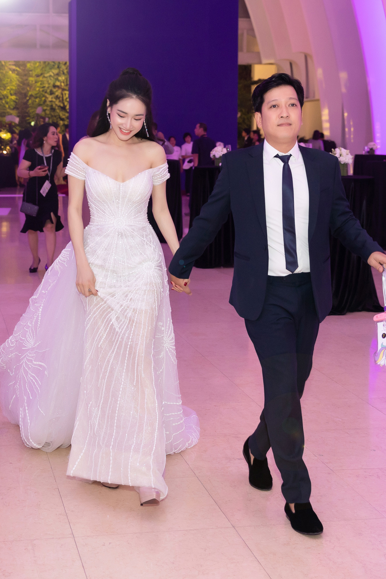 Nhã Phương được stylist Hoàng Ku chọn cho một chiếc đầm dạ hội màu trắng hoạ tiết đính hạt tinh tế của NTK Lê Thanh Hoà để khéo léo khoe bờ vai trần và phần xương quai xanh gợi cảm.