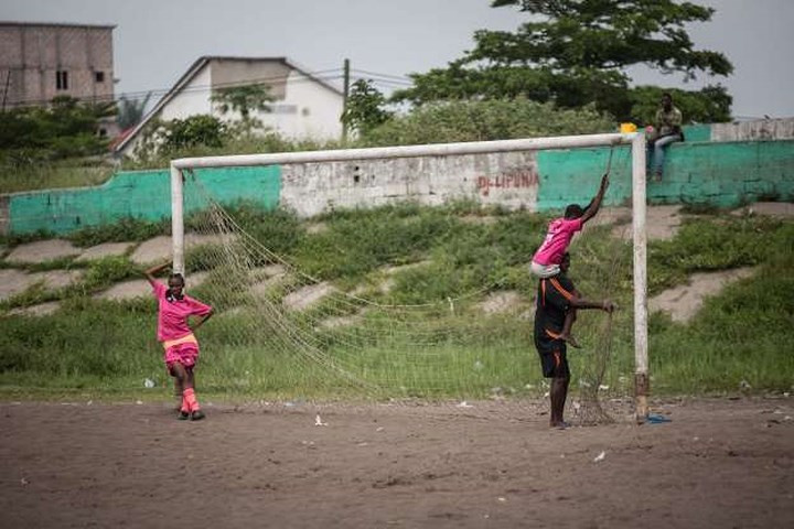 Các cầu thủ bóng đá đang cố gắng sửa lại khung thành cũ kĩ ở Kinshasa, Cộng hòa Congo.