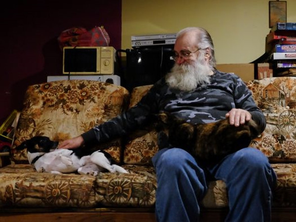 Ông Kirby trên chiếc sofa cũ mà ông mua từ cửa hàng bán đồ từ thiện.