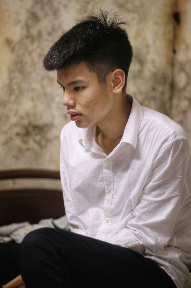 Đ.A ngồi thẫn thờ trong căn nhà nhỏ, nơi mẹ em đã không còn trở về sau những ca làm khuya. (Ảnh: Dantri)