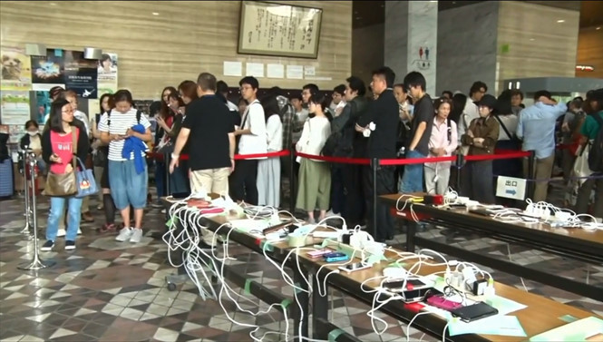 Người dân chờ sạc điện thoại ở Hokkaido. ẢNH CHỤP TỪ CLIP.