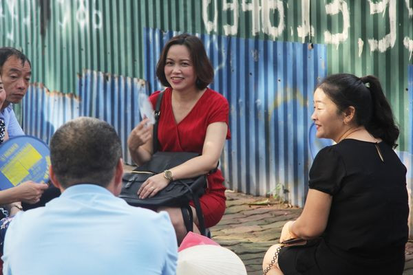 Bên ngoài điểm thi, phụ huynh ngồi trò chuyện đợi con em mình.