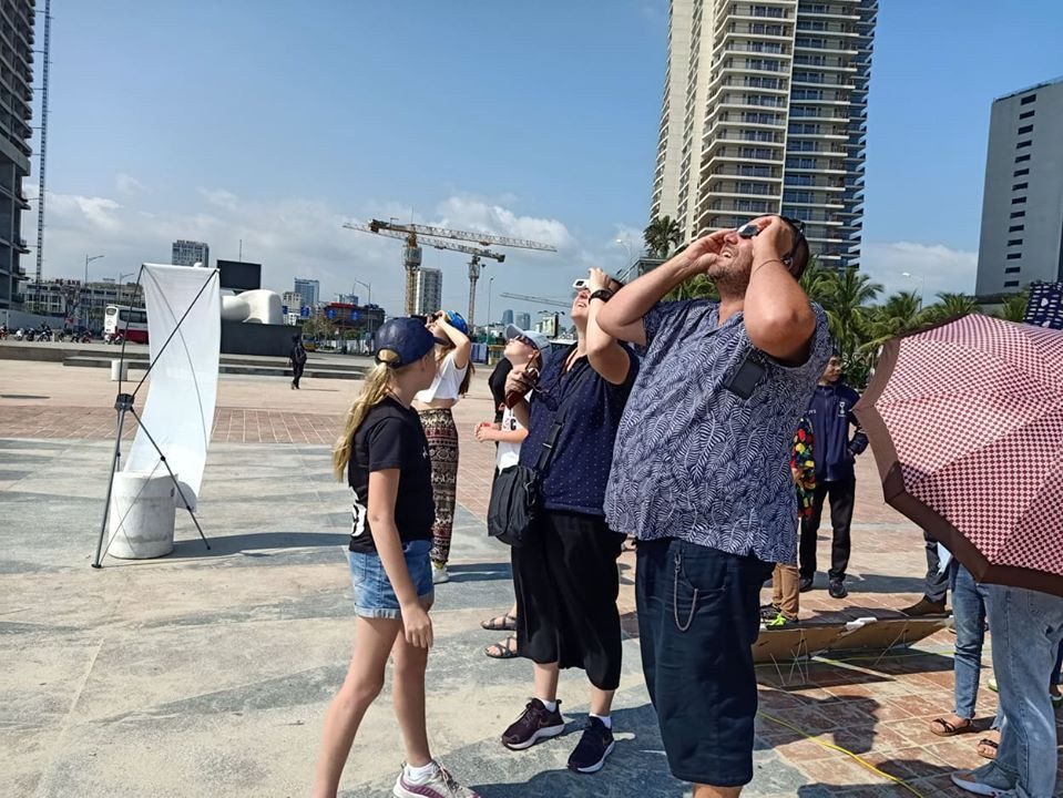 Du khách ngắm nhật thực bằng kính chuyên dụng. (Ảnh: DAC)