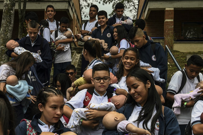 Học sinh nhận nuôi những em bé robot. Ảnh: AFP.