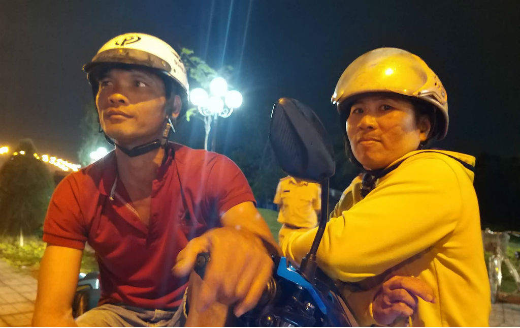 Vợ chồng anh Hữu Nhân (ngụ tại Bến Lức) đứng gần hiện trường, nhưng người vợ không dám nhìn vì quá sợ hãi. (Ảnh: Hoàng Lam)