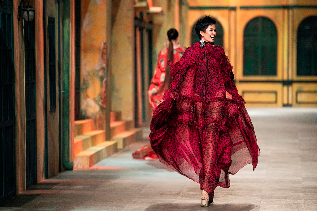 H’Hen Niê diện bodysuit bên trong kết hợp với thiết kế phom rông bên ngoài, trên nền vải chiffon mềm mại, có độ bồng bềnh, lướt nhẹ theo từng chuyển động của người đẹp. Hoạ tiết da báo phù hợp với sự năng động, mạnh mẽ có phần phóng khoáng của H’Hen Niê.