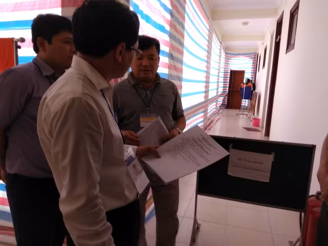 Ông Mai Văn Trinh, Cục trưởng Cục Quản lý chất lượng kiểm tra biên bản mở túi bài thi ở khu vực chấm thi trắc nghiệm của Hòa Bình.