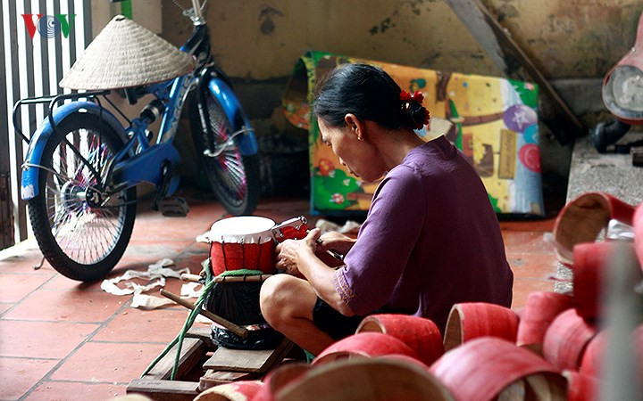 Ảnh: Người thợ dùng súng bắn ghim để bọc mặt trống.