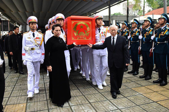 Tổng Bí thư Nguyễn Phú Trọng, Chủ tịch Quốc hội Nguyễn Thị Kim Ngân đưa linh cữu Chủ tịch nước Trần Đại Quang ra linh xa trong sân nhà tang lễ.