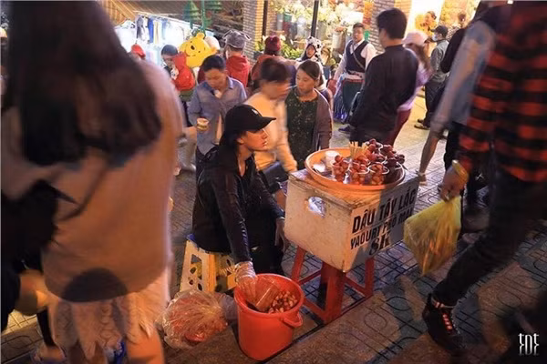 Đồ ăn vặt vỉa hè tăng giá nhưng vẫn rất đông khách đến mua.