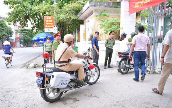 Hai cán bộ công an “hộ tống” nữ thí sinh. (Ảnh: Tuổi Trẻ Online)