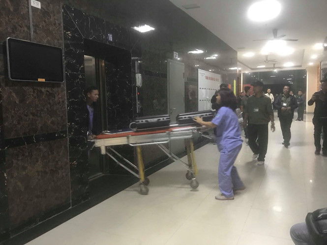 Nhân viên y tế lên đón nữ bệnh nhân xuống xe cứu thương. ẢNH: TRẦN CƯỜNG.