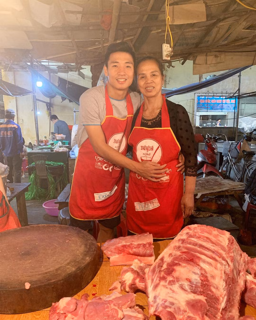 Trung vệ điển trai chụp hình kỉ niệm cùng mẹ và những cô bán hàng.