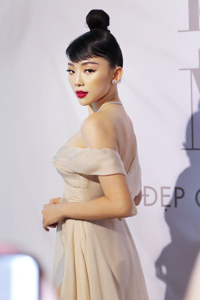 Ca sĩ Tóc Tiên vừa hiện đại vừa cổ điển với lối trang điểm cá tính, nhấn mạnh đôi môi đỏ, mắt kẻ eyeliner cong vút. Mái tóc búi cao khác lạ gợi nhớ đến nữ diễn viên huyền thoại Audrey Hepburn.