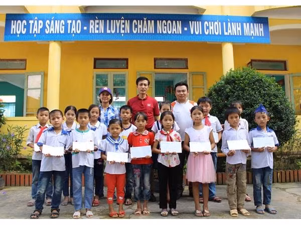 Thầy Hiệu trưởng trường Tiểu học Lộc Yên (đứng giữa) và các cán bộ của Quỹ học bổng Vừ A Dính, Báo TNTP trao tặng Học bổng Vừ A Dính.